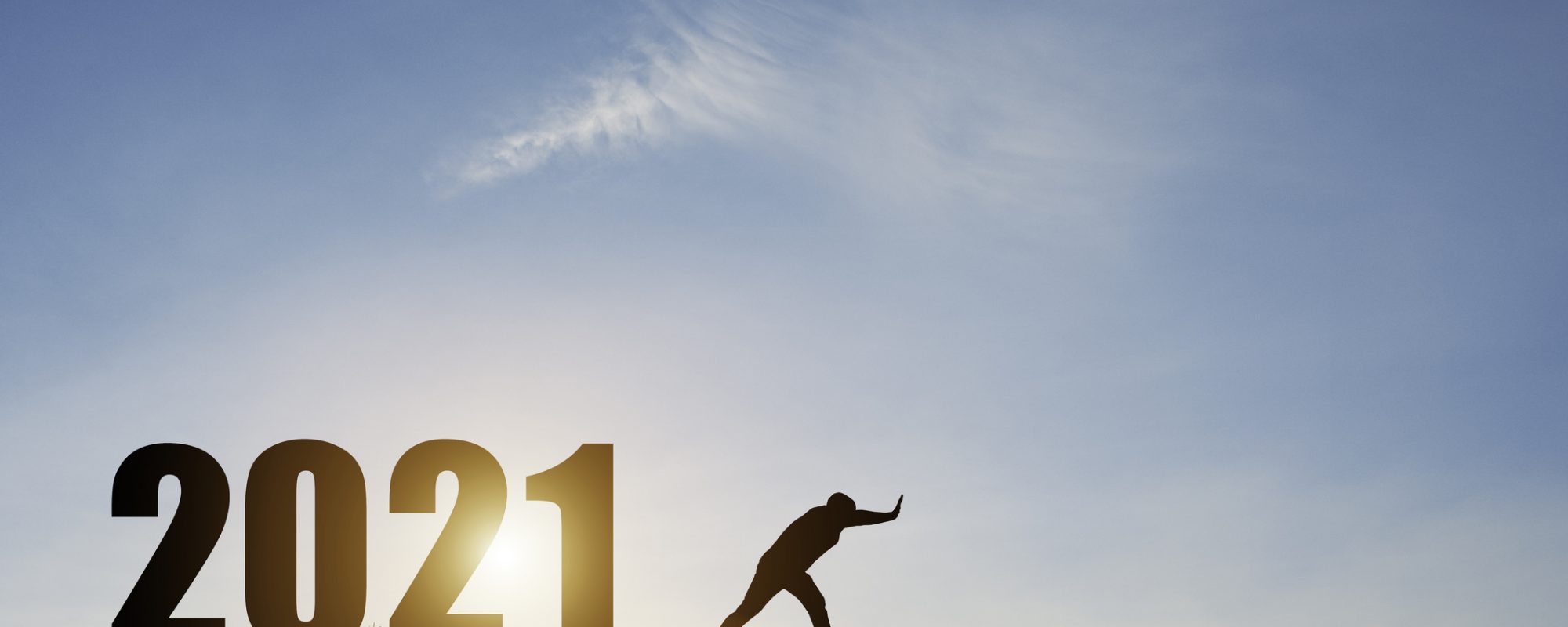 Man push number zero down the cliff where has the number 2021 with blue sky and sunrise. It is symbol of starting and welcome happy new year 2021.
